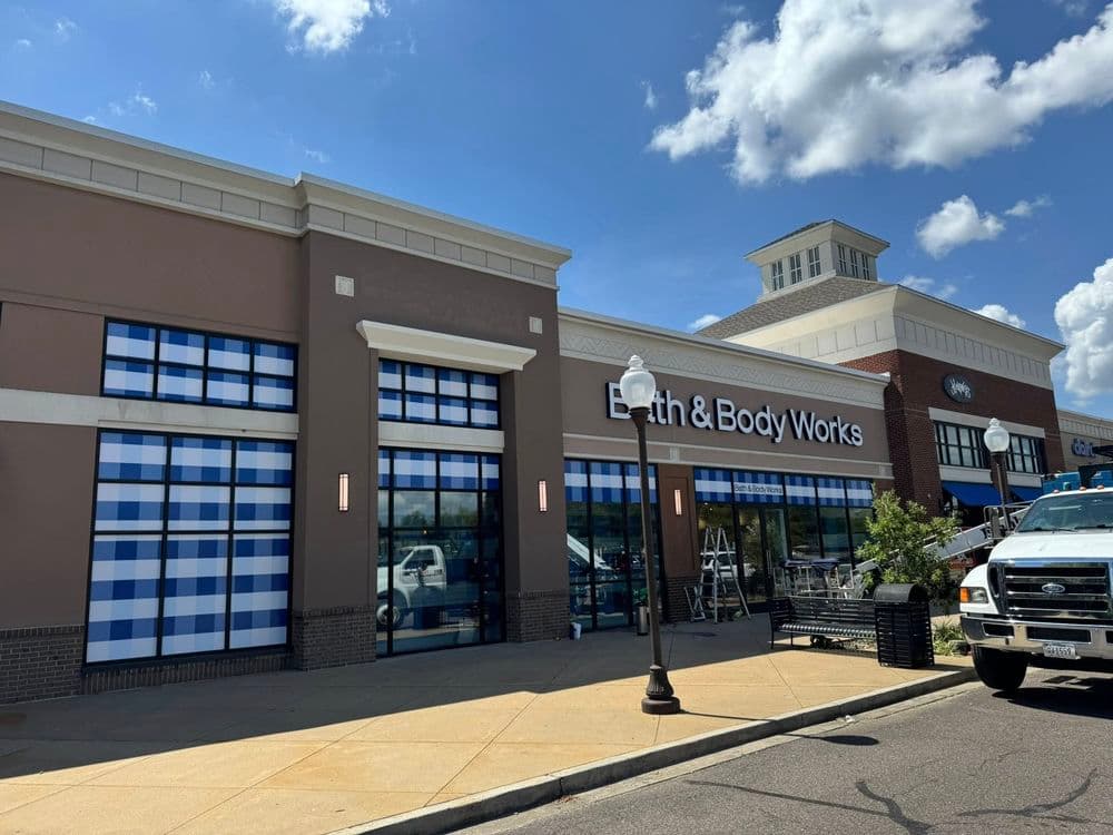 Bath & Body Works storefront featuring blue checkered window displays and clear skies.